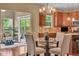 Open dining area featuring a modern chandelier, glass table, and stainless steel appliances at 8704 New Heritage Dr, Indianapolis, IN 46239