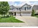 Beautiful two-story home with a brick and siding exterior, mature tree, and manicured lawn at 8704 New Heritage Dr, Indianapolis, IN 46239