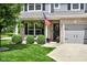 Inviting front porch with seating and lush landscaping, including an American flag at 8704 New Heritage Dr, Indianapolis, IN 46239