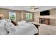 Main bedroom boasting a ceiling fan, large windows, a fireplace, and a wall-mounted TV, creating a comfortable retreat at 8704 New Heritage Dr, Indianapolis, IN 46239