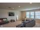 Spacious living room with plush carpeting, a TV, a gray sofa, and plenty of natural light at 8732 Wicklow Way, Brownsburg, IN 46112
