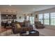 Open-concept living room, connecting the kitchen and dining areas, with large windows and modern furniture at 8732 Wicklow Way, Brownsburg, IN 46112