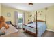 Charming bedroom with a four-poster bed, soft blue comforter, and cozy seating area at 9179 Brookstone Pl, Zionsville, IN 46077