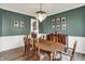 Formal dining room with hardwood floors, a crystal chandelier, and dark green accent walls at 9179 Brookstone Pl, Zionsville, IN 46077