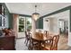 Dining room with wood floors, chandelier, light pink curtains, and neutral wall colors at 9179 Brookstone Pl, Zionsville, IN 46077