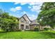 Charming two-story home featuring a stone and brick facade, lush lawn, and mature trees at 9179 Brookstone Pl, Zionsville, IN 46077
