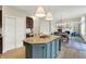 View of the kitchen island with bar seating, opening up to the living room and dining area at 9179 Brookstone Pl, Zionsville, IN 46077