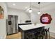 Modern kitchenette with stainless steel refrigerator, white countertops, and bar seating at 9179 Brookstone Pl, Zionsville, IN 46077