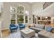 Sunlit living room with hardwood floors and an open floor plan showcasing seamless access to the kitchen at 9179 Brookstone Pl, Zionsville, IN 46077