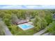 Aerial view of a community pool, tennis courts and verdant trees in summer at 9324 W Point Pl, Indianapolis, IN 46268