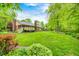 Large backyard with mature trees, lush landscaping, and green lawn at 9324 W Point Pl, Indianapolis, IN 46268