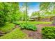 Landscaped backyard with mature trees and a creek at 9324 W Point Pl, Indianapolis, IN 46268