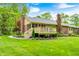 Expansive backyard with a deck, mature trees, and green lawn at 9324 W Point Pl, Indianapolis, IN 46268