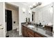 Well-appointed bathroom featuring dark wood vanity, elegant light fixtures, and black and white floors at 9324 W Point Pl, Indianapolis, IN 46268