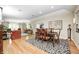 Open-concept dining area with hardwood floors, a stylish table setting, and a view into the living room at 9324 W Point Pl, Indianapolis, IN 46268