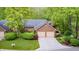 Charming brick home featuring a two-car garage and lush, mature landscaping at 9324 W Point Pl, Indianapolis, IN 46268