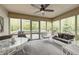 Relaxing screened-in porch with ceiling fan, outdoor furniture, and views of the backyard at 9324 W Point Pl, Indianapolis, IN 46268