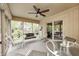 Bright sunroom with ceiling fan, neutral decor, and views of backyard trees and a home at 9324 W Point Pl, Indianapolis, IN 46268