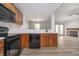 Modern kitchen features wooden cabinets, a black appliance package, and an open view to the living area at 1008 Canary Creek Ct, Franklin, IN 46131