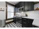 Modern kitchen features black cabinetry, stainless steel appliances, and geometric tile flooring at 108 E Saint Clair St # E, Indianapolis, IN 46204