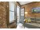 Inviting living room features exposed brick walls and a cozy gray sofa near the entry door at 108 E Saint Clair St # E, Indianapolis, IN 46204