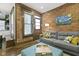 Comfortable living room with exposed brick wall, gray sofa, and a stylish blue ottoman at 108 E Saint Clair St # E, Indianapolis, IN 46204