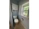Cozy bathroom with a toilet and overhead cabinet by the window at 1122 Shelby St, Shelbyville, IN 46176
