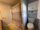 Bathroom with striped shower curtain and toilet with storage cabinet above at 1122 Shelby St, Shelbyville, IN 46176