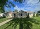 Charming single-story home featuring a well-maintained lawn and mature trees under a blue sky at 1122 Shelby St, Shelbyville, IN 46176