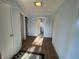 Hallway with wood floors, three doors, and neutral paint, leading to other rooms at 1122 Shelby St, Shelbyville, IN 46176