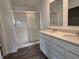 Bathroom featuring double sinks, modern fixtures, a walk-in shower, and vinyl plank flooring at 11302 N Quillow Way, Monrovia, IN 46157