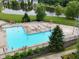 Community swimming pool with lounge chairs, umbrellas, and a scenic pond view offers relaxation and recreation at 11302 N Quillow Way, Monrovia, IN 46157