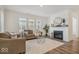 Bright living room with a fireplace, wood floors, and large windows at 11469 Lottie Cir, Noblesville, IN 46060