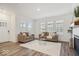 Bright living room with a fireplace, wood floors, and large windows at 11469 Lottie Cir, Noblesville, IN 46060