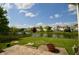 Spacious backyard with lush green grass, a pond, and a paved patio at 11850 Stepping Stone Dr, Fishers, IN 46037