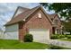 Brick house showing the side, including the garage and landscaping at 11850 Stepping Stone Dr, Fishers, IN 46037