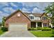 Charming brick home featuring a two-car garage, well-manicured lawn, and classic architectural details at 11850 Stepping Stone Dr, Fishers, IN 46037