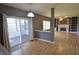 Open-concept living and dining area with hardwood floors, fireplace, and sliding glass doors to sunroom at 11850 Stepping Stone Dr, Fishers, IN 46037