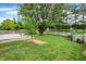 Green backyard featuring a wooden deck, a large tree, grass, and a wooden fence, ideal for outdoor living at 12257 Driftstone Dr, Fishers, IN 46037