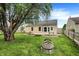 Large backyard with well-kept lawn area, stone fire pit, and wooden deck at 12257 Driftstone Dr, Fishers, IN 46037