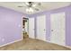 Carpeted bedroom with 3 doors, ceiling fan, and view into ensuite bathroom with tile floor at 12257 Driftstone Dr, Fishers, IN 46037