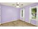 Cozy bedroom with neutral carpet, lavender walls, ceiling fan, and two windows with natural light at 12257 Driftstone Dr, Fishers, IN 46037