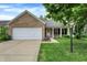 Charming brick home with a well-maintained lawn, attached garage, and inviting front porch at 12257 Driftstone Dr, Fishers, IN 46037