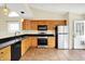 Well-lit kitchen featuring stainless steel appliances, tile flooring and dark countertops at 12257 Driftstone Dr, Fishers, IN 46037