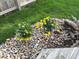 Landscaping bed featuring decorative river rock, plantings and flowers by a wooden deck at 12257 Driftstone Dr, Fishers, IN 46037