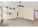 Open-concept living room with neutral tones, ceiling fan, and view into the kitchen at 12257 Driftstone Dr, Fishers, IN 46037