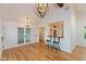 Open-concept dining area with hardwood floors, modern lighting fixtures, and breakfast bar with stools at 12290 Charing Cross Rd, Carmel, IN 46033