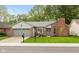 Charming single-story home with a brick chimney, gray siding, well-maintained lawn, and an attached two-car garage at 12290 Charing Cross Rd, Carmel, IN 46033