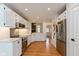 Bright kitchen features white cabinets, stainless steel appliances, and hardwood floors at 12290 Charing Cross Rd, Carmel, IN 46033
