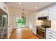 Bright kitchen features stainless steel appliances, white cabinets, hardwood floors, and a sliding glass door to the backyard at 12290 Charing Cross Rd, Carmel, IN 46033